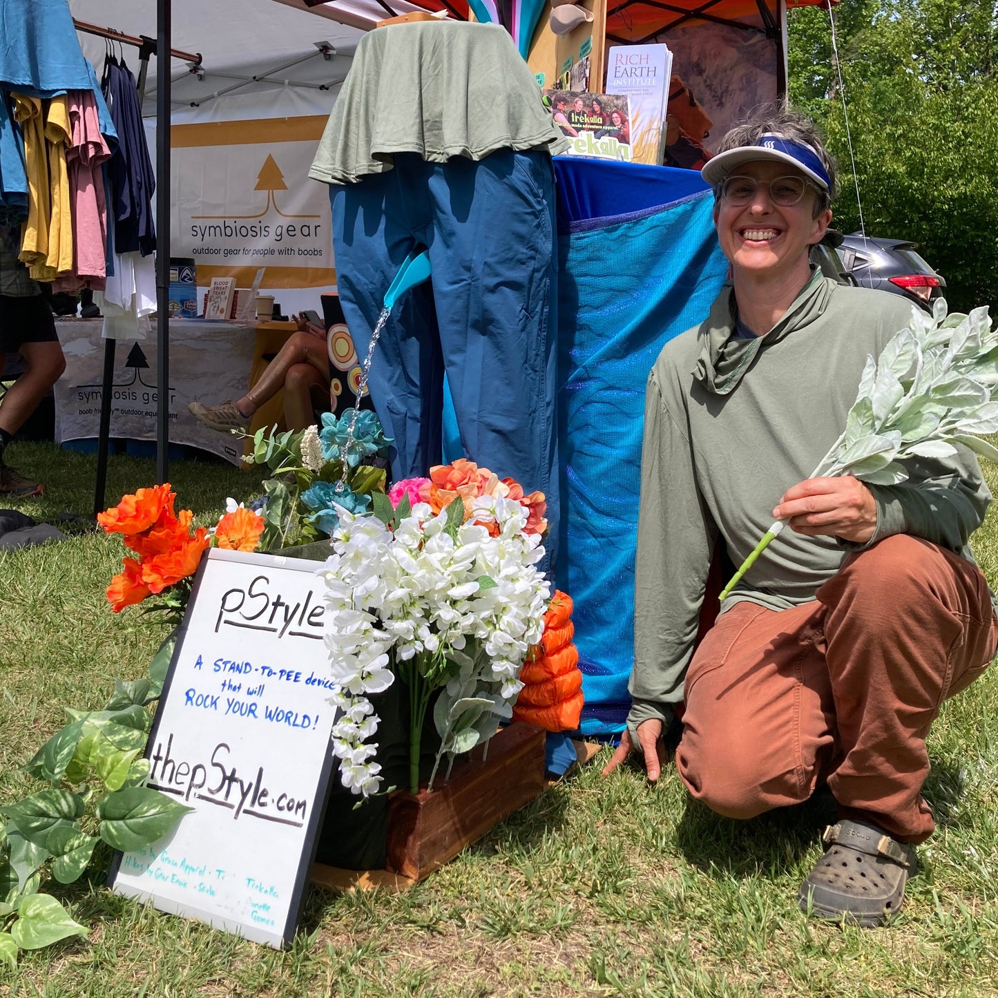 Booth set up showing the pStyle fountain in use. Krista is kneeling next to it with some flowers in her hand. 