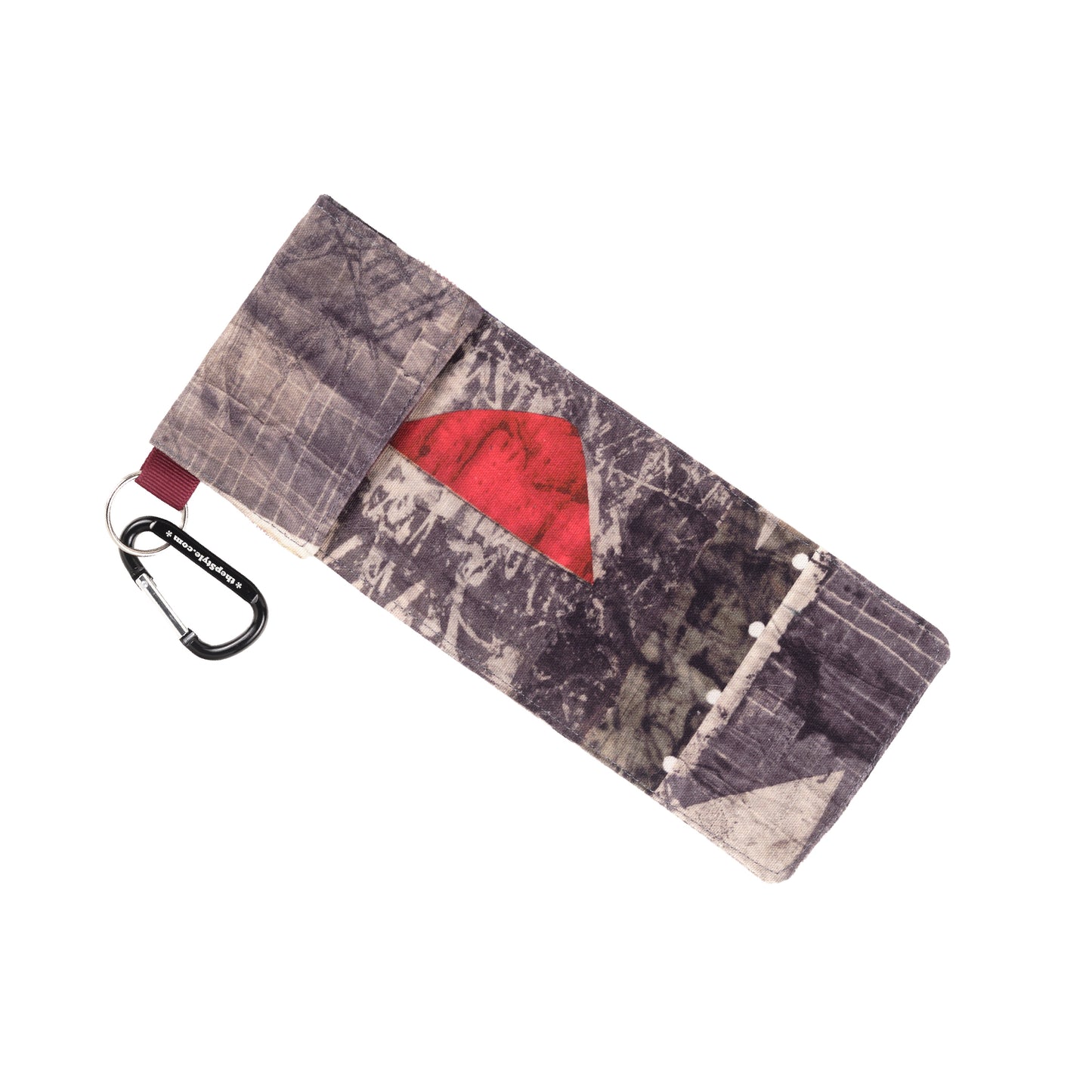 Gemstone comes from a fabric with a lot of different designs on it. Generally it has a dark grey background and pops of bright orange and red shapes. No two cases are alike. The ribbon is maroon and the carabiner is black. 