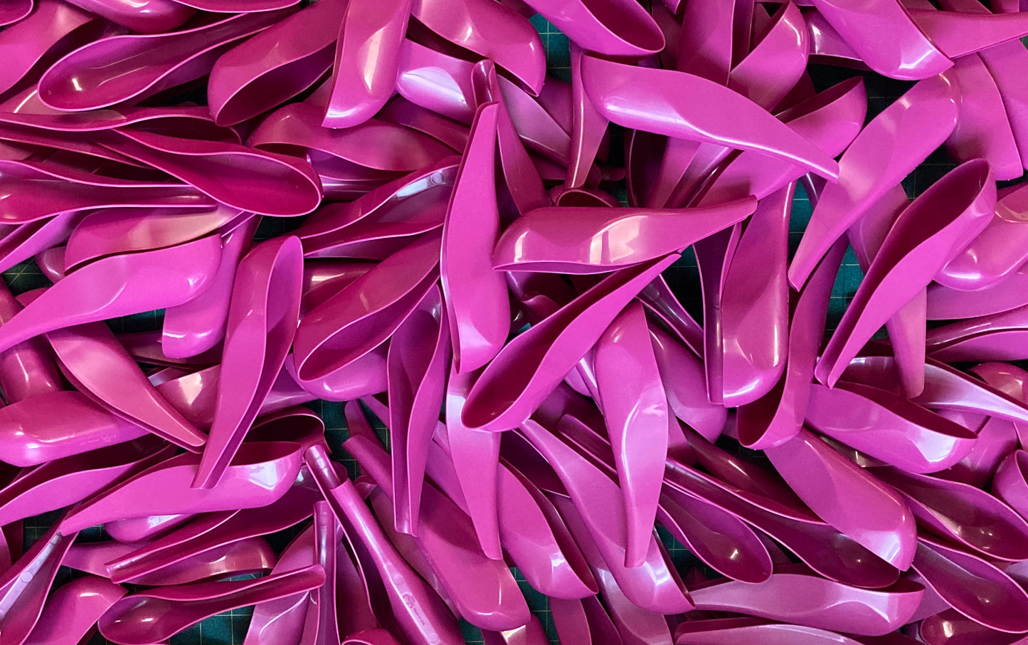 Dozens of fuchsia pStyles spread on a table. 