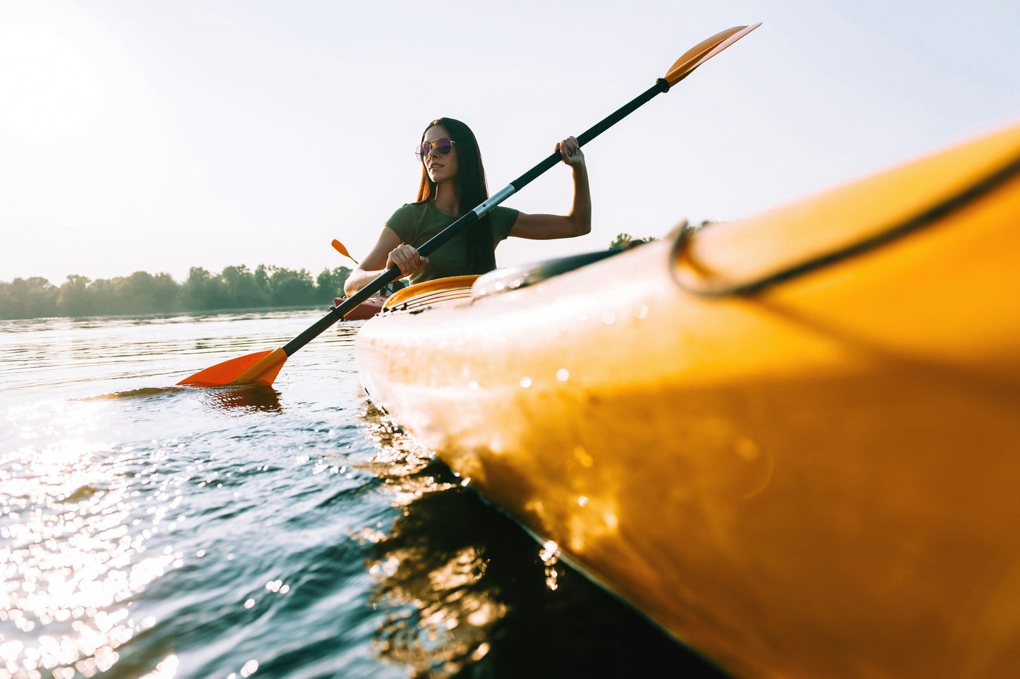 A person rowing a kayak on a lake. 