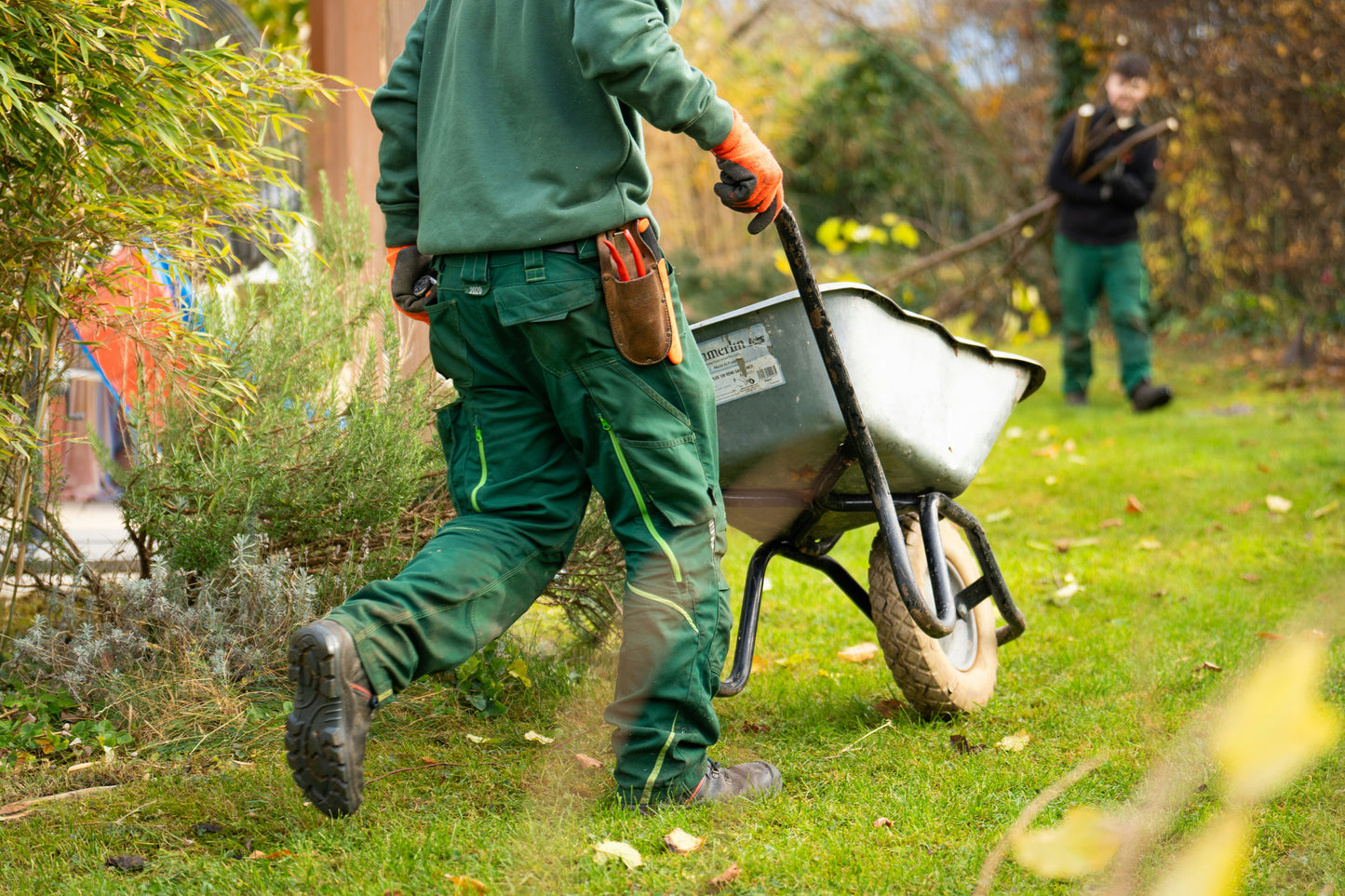 A person pushing a wheelbarrow. 